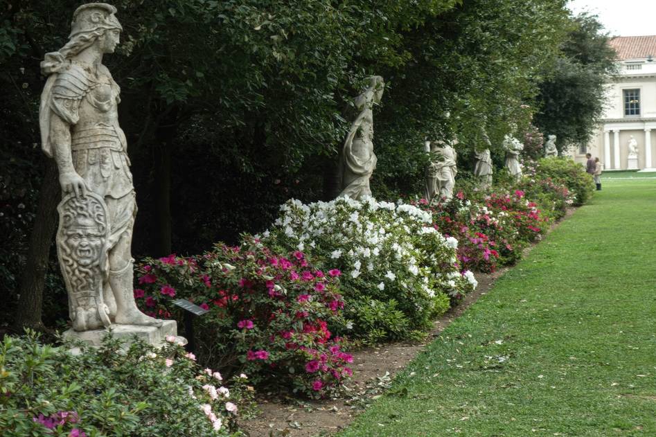 Blogger arranging elegant stone statues in a peaceful garden setting