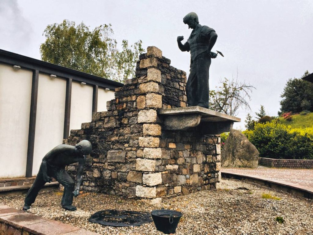 concrete statues near brick wall