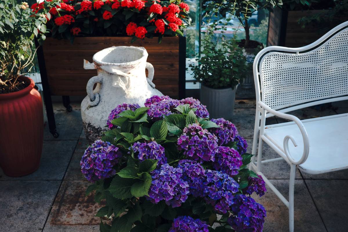 outdoor garden ideas with pots arranged around a central stone garden statue